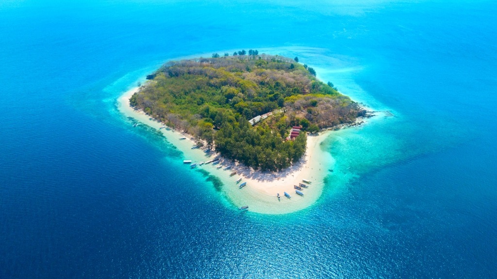 Aerial view of a serene Gili island surrounded by the azure sea, a stop on the Secret Gilis Snorkeling Tour